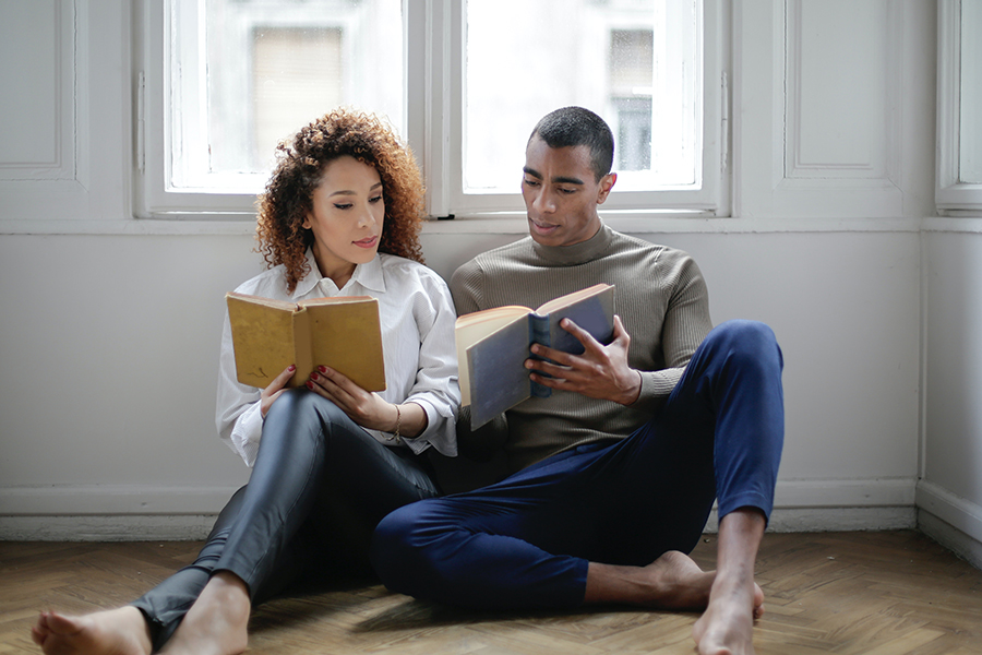 Pareja joven hablando y leyendo juntos