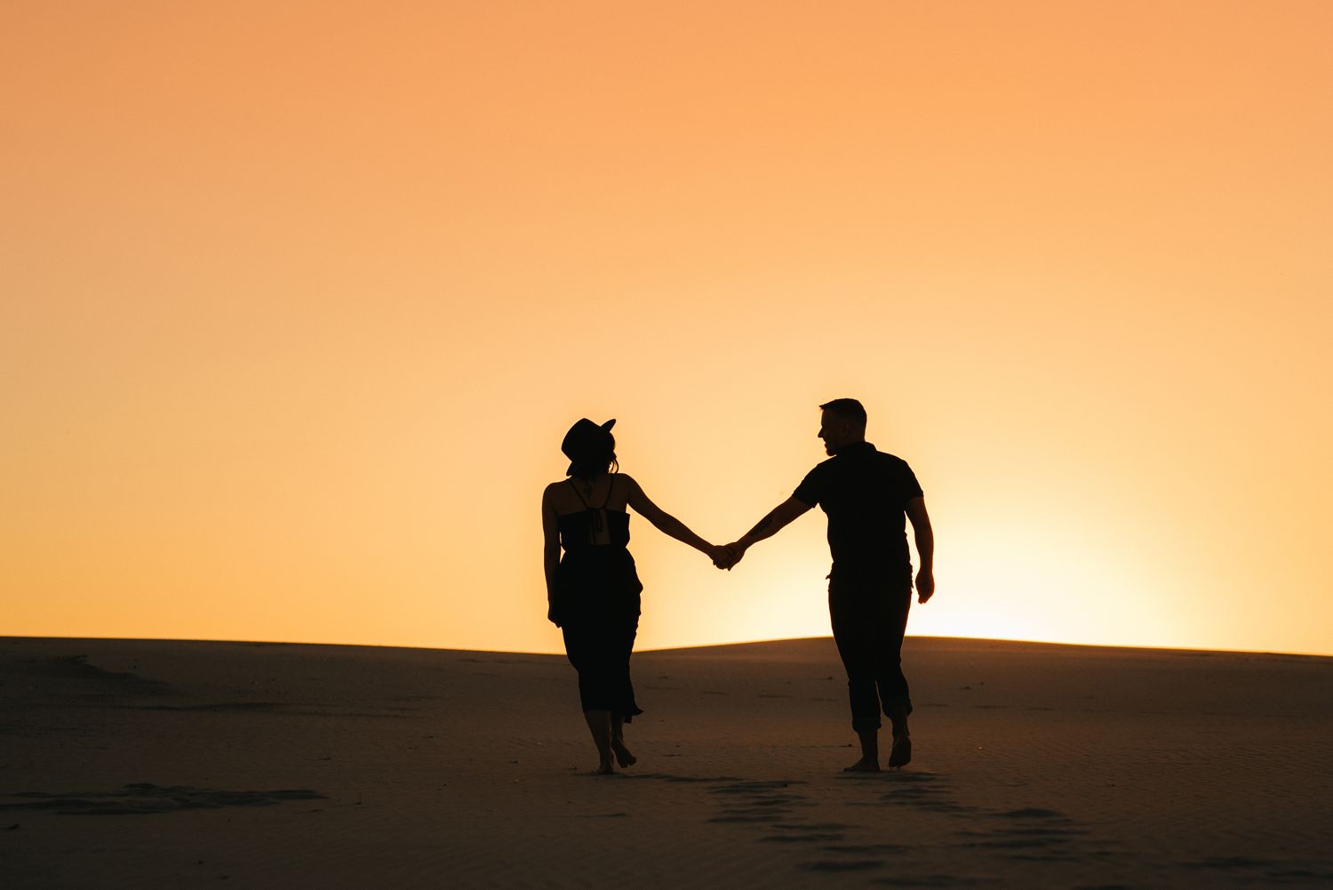 Silueta de una pareja en la playa al atardecer